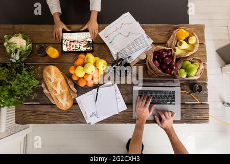 High angle view of people using digital devices in kitchen Stock Photo
