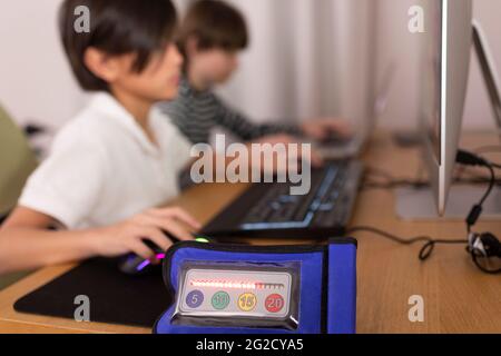Close-up of timer, boys using computers on background Stock Photo