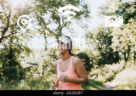 Woman jogging with headphones connected to various internet services Stock Photo