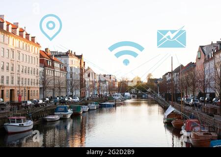 Boats in canal and townhouses and various Internet services icons Stock Photo