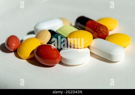 Pills of different colors and shapes on a white background.different treatment methods.close-up.pills and capsules pills  in red yellow green Stock Photo