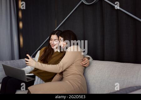 Female coworkers taking selfie on sofa Stock Photo