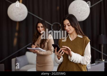 Young woman at work using cell phone Stock Photo