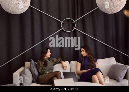 Businesswomen talking on sofa Stock Photo