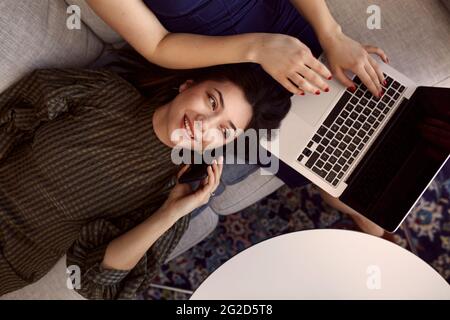 Businesswoman talking via cell phone on sofa Stock Photo