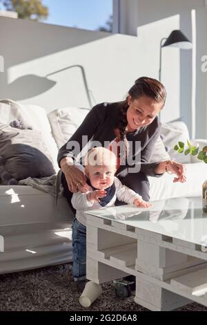 Smiling mother with baby boy on sofa Stock Photo