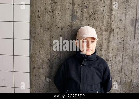 Boy wearing baseball cap looking away Stock Photo