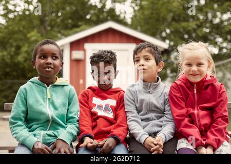 Smiling children sitting together and looking at camera Stock Photo