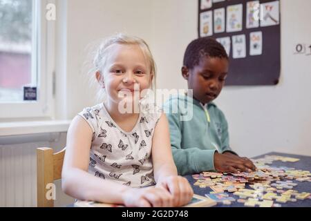 Boy and girl doing puzzle in classroom Stock Photo