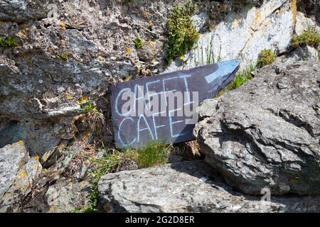 Bilingual Welsh / English handmade slate sign for 'Caffi / Cafe' on Ynys Enlli / Bardsey Island which stands in front of the former lime kiln Stock Photo