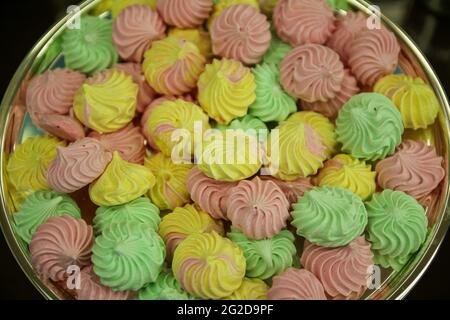 Sweet homemade colorful meringue pastries, yellow, pink, green desserts Stock Photo