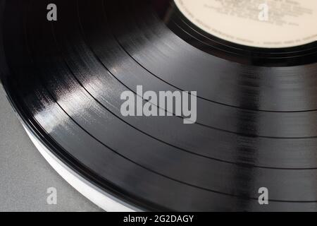 Part of vinyl record playing on old turntable. Detail of vinyl LP showing texture and music tracks Stock Photo