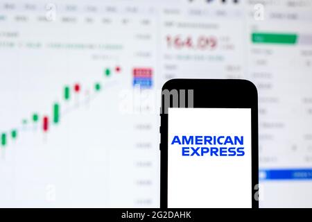 In this photo illustration an American Express logo seen displayed on a smartphone with the stock market information of American Express in the background. Stock Photo