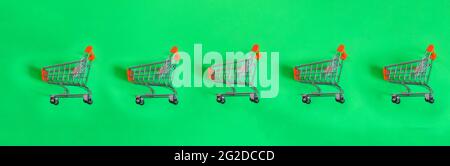 Mini shopping carts, mini shopping carts on isolated green background, top view. Stock Photo