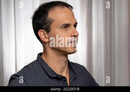 Mature man (44 years old) in photo session with dark blue polo shirt, making several faces. Stock Photo