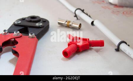 Repair of a broken pipe in the underfloor heating system. Plumbing Tools Stock Photo