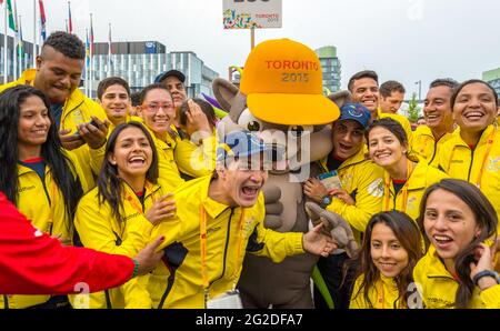 Athletes from Ecuador in joyful mood posing for photograph with the mascot Pachi the Porcupine at the 2015 Pan Am Games, Toronto. Pan-Am Games were a Stock Photo