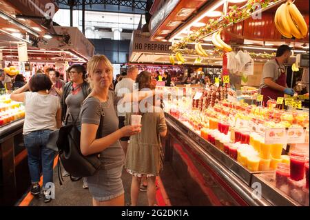 A woman in a food market in the Spanish city of Bareclona looking at food stalls and produce. Stock Photo