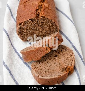 Whole grain rye bread in slices on white kitchen towel Stock Photo