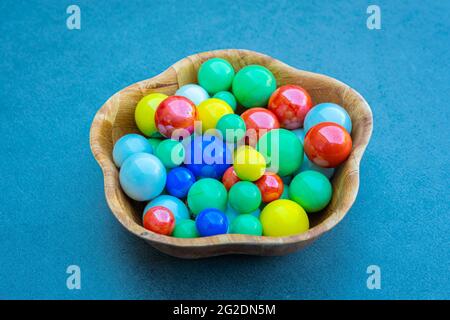 Wooden bowl with colorful marbles on a table Stock Photo