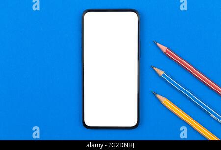 School and studying smartphone mockup, blue office table with pencil, top view photo Stock Photo