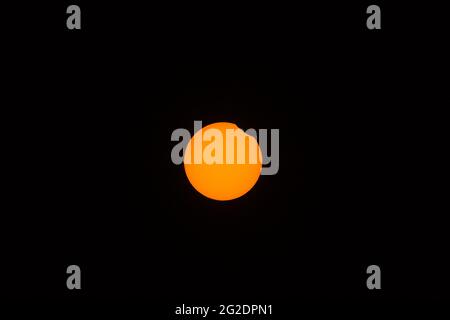 Beautiful centered view of partial (annular) eclipse visible in Irish skies on June 10, 2021, Dublin, Ireland. The beginning phase Stock Photo