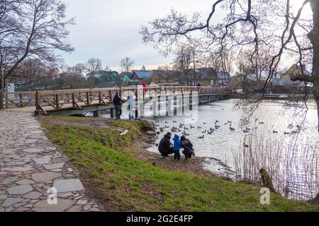 Trakai, Lithuania - February 16, 2020: A group of people enjoy sunset on a lake. Wooden bridge near Island Castle in Trakai, Vilnius County, Lithuania Stock Photo