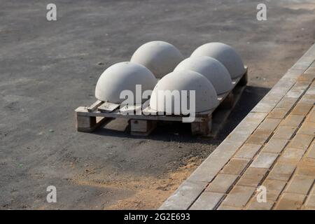 Blocks of movement of cars in the pedestrian zone. The concrete blocks are awaiting installation. Parking restrictor of vehicle passage. Concrete sphe Stock Photo