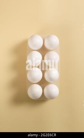 White chicken eggs lie in an egg tray. Healthy food concept. Vertical orientation. Stock Photo