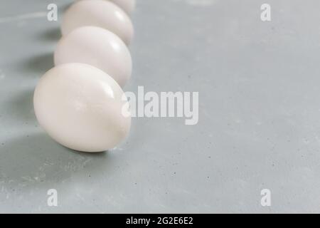 Five white chicken eggs lie on a gray background. Healthy nutrition concept. Top view. Stock Photo
