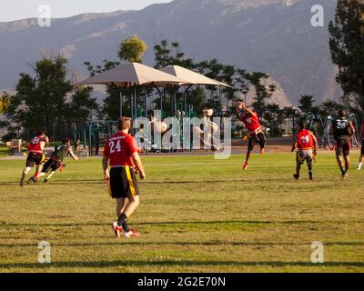 Young men playing flag football at a public park. Stock Photo