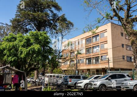 A residential building located at the streets of Higino da Silveira square with many cars parked 45 degrees in front under sunny clear blue sky. Stock Photo
