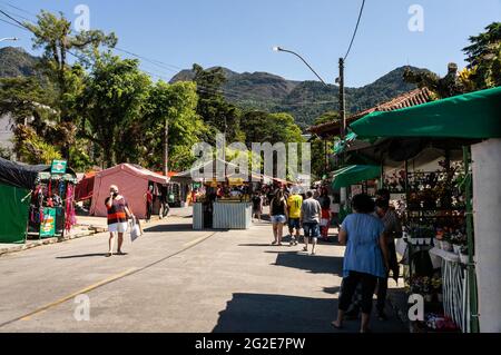 People walking and browsing items for sale in Alto Fair, a public market located in the surroundings of Higino da Silveira square, Alto district. Stock Photo