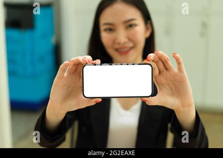 Businesswoman hands holding smartphones with horizontal mock-up screen and showing to camera Stock Photo