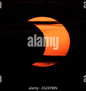 A partial solar eclipse is seen from Arlington, Virginia, Thursday, June 10, 2021.  The annular or “ring of fire” solar eclipse is only visible to some people in Greenland, Northern Russia, and Canada. Photo Credit: (NASA/Bill Ingalls) Stock Photo