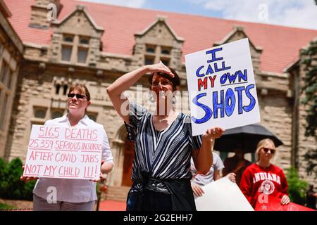 Bloomington, US. 10th June 2021. Protesters holding placards gather at Indiana University's Sample Gates during the demonstration.Anti-vaxxers and anti-maskers gathered at Indiana University's Sample Gates to protest against mandatory Covid vaccinations IU is requiring for students, staff and faculty during the upcoming fall semester. The protesters say their constitutional rights are being infringed, and have launched a law suit. Credit: SOPA Images Limited/Alamy Live News Stock Photo