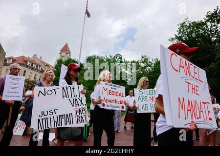 Bloomington, US. 10th June 2021. Protesters hold placards during the demonstration.Anti-vaxxers and anti-maskers gathered at Indiana University's Sample Gates to protest against mandatory Covid vaccinations IU is requiring for students, staff and faculty during the upcoming fall semester. The protesters say their constitutional rights are being infringed, and have launched a law suit. Credit: SOPA Images Limited/Alamy Live News Stock Photo