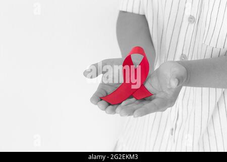 Burgundy ribbon in lady hands, multiple myeloma syndrome awareness,  healthcare Stock Photo