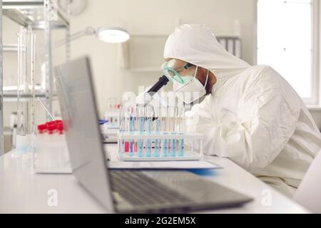 Scientist working in laboratory, using microscope, doing research and developing new vaccine Stock Photo