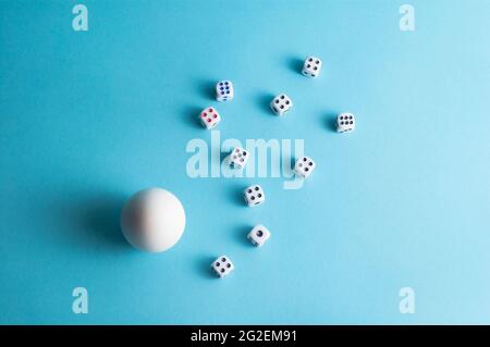 Minimal layout with a white egg and dice on blue background Stock Photo