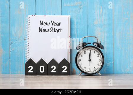 2022 Happy New Year with New Year New start, black retro alarm clock and wooden number.Resolution, Goals, Plan, Action and Mission Concept Stock Photo