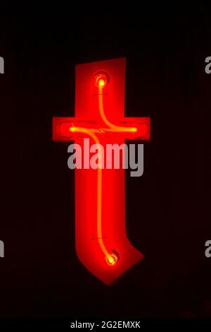 Red glowing neon lowercase letter t at night Stock Photo