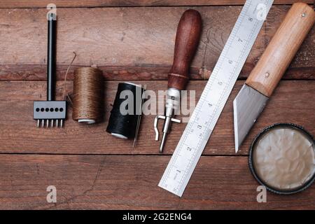 Set of Leather crafting tools. Shoes maker tools on wooden table Stock Photo
