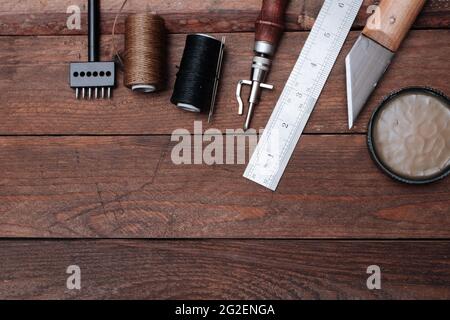 Set of Leather crafting tools. Shoes maker tools on wooden table. Stock Photo