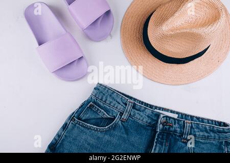 Casual women's clothing, acccessories. Summer slippers, shorts, straw hat Stock Photo