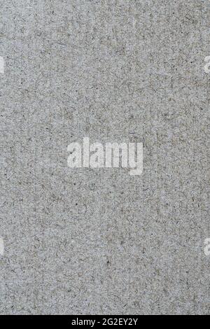 Texture from sheet of recycled light brown cardboard. Close-up vertical view of abstract recycled eco-friendly material pattern background. Stock Photo