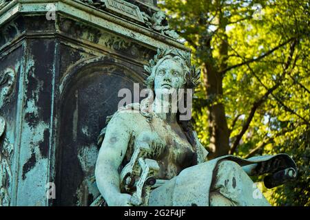 Female bronze sculpture as part of the Peter von Cornelius monument. It was erected in 1879. Location: In Germany’s oldest public garden, 'Hofgarten'. Stock Photo