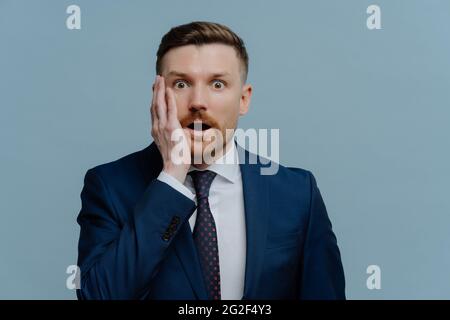 Surprised businessman receiving negative news and feeling shocked Stock Photo