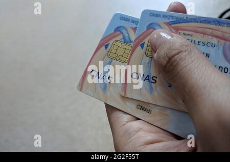 2 May 2019, Bucharest, Romania Woman hol ding two CNAS Health Cards. Romanian Health Card Stock Photo