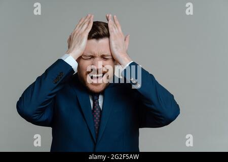 Upset businessman feeling stressed of failure at work Stock Photo